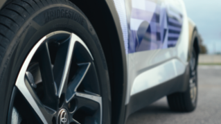 A close up shot of a Bridgestone Turanza 6 tire with ENLITEN technology on a Paris 2024 Toyota C-HR hybrid vehicle.